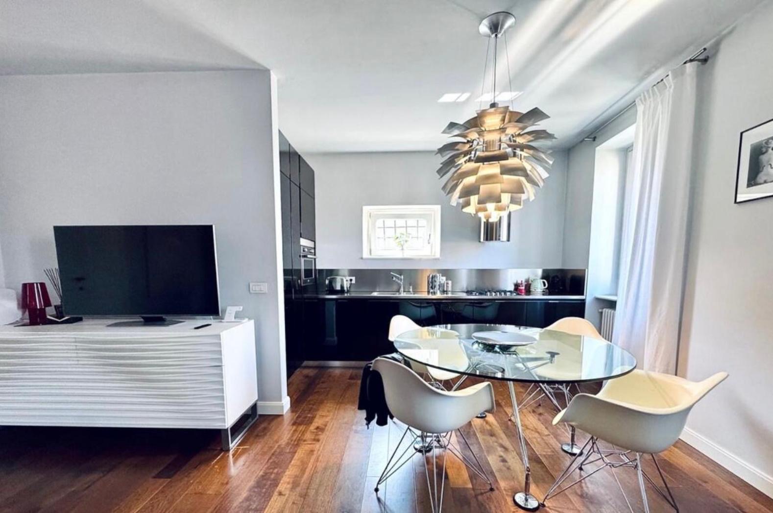 Tavolo da pranzo in vetro con sedie in stile Eames