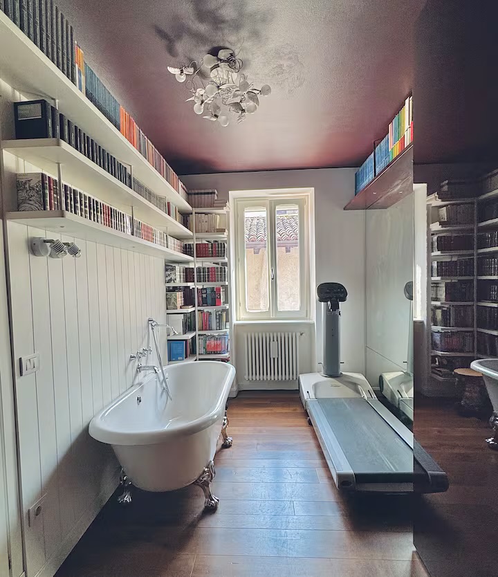 Stanza relax con libreria, vasca freestanding e tapis roulant