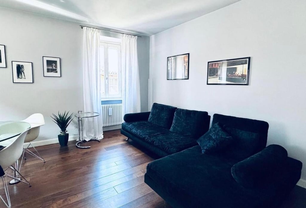 Divano in velluto scuro e parquet in rovere